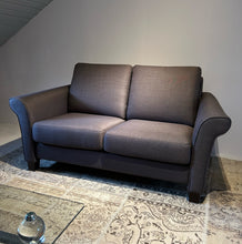 Laden Sie das Bild in den Galerie-Viewer, Frontansicht des Schröno Sofa Individual in braunviolettem JAB Anstoetz Stoff Vito 55 auf Teppich mit Glas-Couchtisch