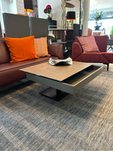 Laden Sie das Bild in den Galerie-Viewer, Stylischer Funktions-Couchtisch Ronald Schmitt Janas K 471 mit Duo‑Höhenverstellung, aufgeschobene Lade rollbar und verschiebbarer Lade im Einrichtungshaus Zeppenfeld in Olpe.

