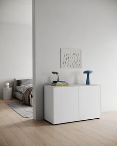 Piure Nex Pur Box 1536778 in Weiß (P01), als Kommode im Wohnbereich mit hellen Holzböden, Designlampe, Büchern und Wandbild – skandinavisch inspiriertes Interieur.