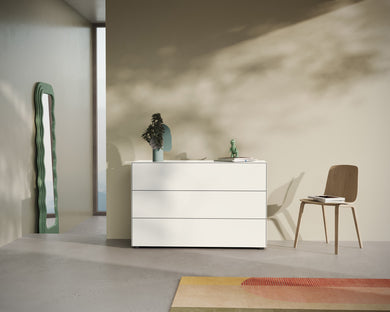 Freistehende Kommode Nex Pur Box 1536776 in weiß
 mit minimalistischer Dekoration vor beiger Wand.