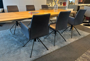 Sechs elegante Esszimmerstühle Arco Iris um einen Holztisch, auf Teppich in Ausstellungsumgebung bei Möbel Zeppenfeld in Olpe