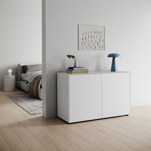 Laden Sie das Bild in den Galerie-Viewer, Piure Nex Pur Box 1536778 in Weiß (P01), als Kommode im Wohnbereich mit hellen Holzböden, Designlampe, Büchern und Wandbild – skandinavisch inspiriertes Interieur.
