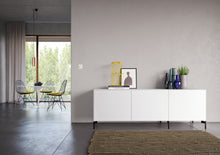Laden Sie das Bild in den Galerie-Viewer, Piure Sideboard 2020600 in Weiß mit Eckfüßen, im modernen Wohn-Essbereich vor grauer Wand – klar, funktional und skandinavisch inspiriert eingerichtet.
