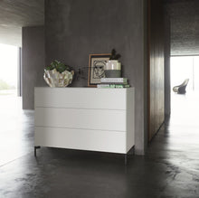 Laden Sie das Bild in den Galerie-Viewer, Nex Pur Box Kommode 1536776 in Weiß mit schwarzen Kufen, stilvoll dekoriert in modernem Interieur.
