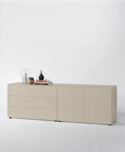Modernes Sideboard in Seidengrau, bestehend aus einem Element mit drei Schüben und einem Element mit zwei Türen, auf einem weißen Studiohintergrund.