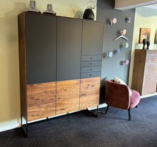 Laden Sie das Bild in den Galerie-Viewer, Scholtissek Geschirrschrank Alleskönner aus Nussbaum mit schwarzen Glastüren und Schubladen, ausgestellt bei Möbel Zeppenfeld in Olpe mit moderner Deko und Sesse
