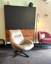 Laden Sie das Bild in den Galerie-Viewer, Scholtissek Geschirrschrank Alleskönner in Nussbaum mit schwarzen Glastüren, ausgestellt bei Möbel Zeppenfeld in Olpe mit Design-Sesseln und Stehleuchte

