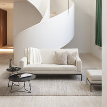 Laden Sie das Bild in den Galerie-Viewer, Bild zeigt das Jori Glove Pure Sofa mit hellem Stoffbezug in moderner Wohnumgebung – luftiges Design mit weichen Rundungen, ideal für skandinavische oder minimalistische Wohnstile.
