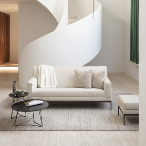 Bild zeigt das Jori Glove Pure Sofa mit hellem Stoffbezug in moderner Wohnumgebung – luftiges Design mit weichen Rundungen, ideal für skandinavische oder minimalistische Wohnstile.