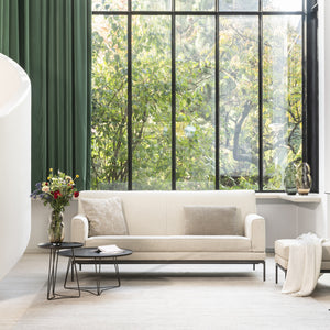 Bild zeigt das Jori Glove Pure Sofa mit hellem Stoffbezug in moderner Wohnumgebung – luftiges Design mit weichen Rundungen, ideal für skandinavische oder minimalistische Wohnstile.